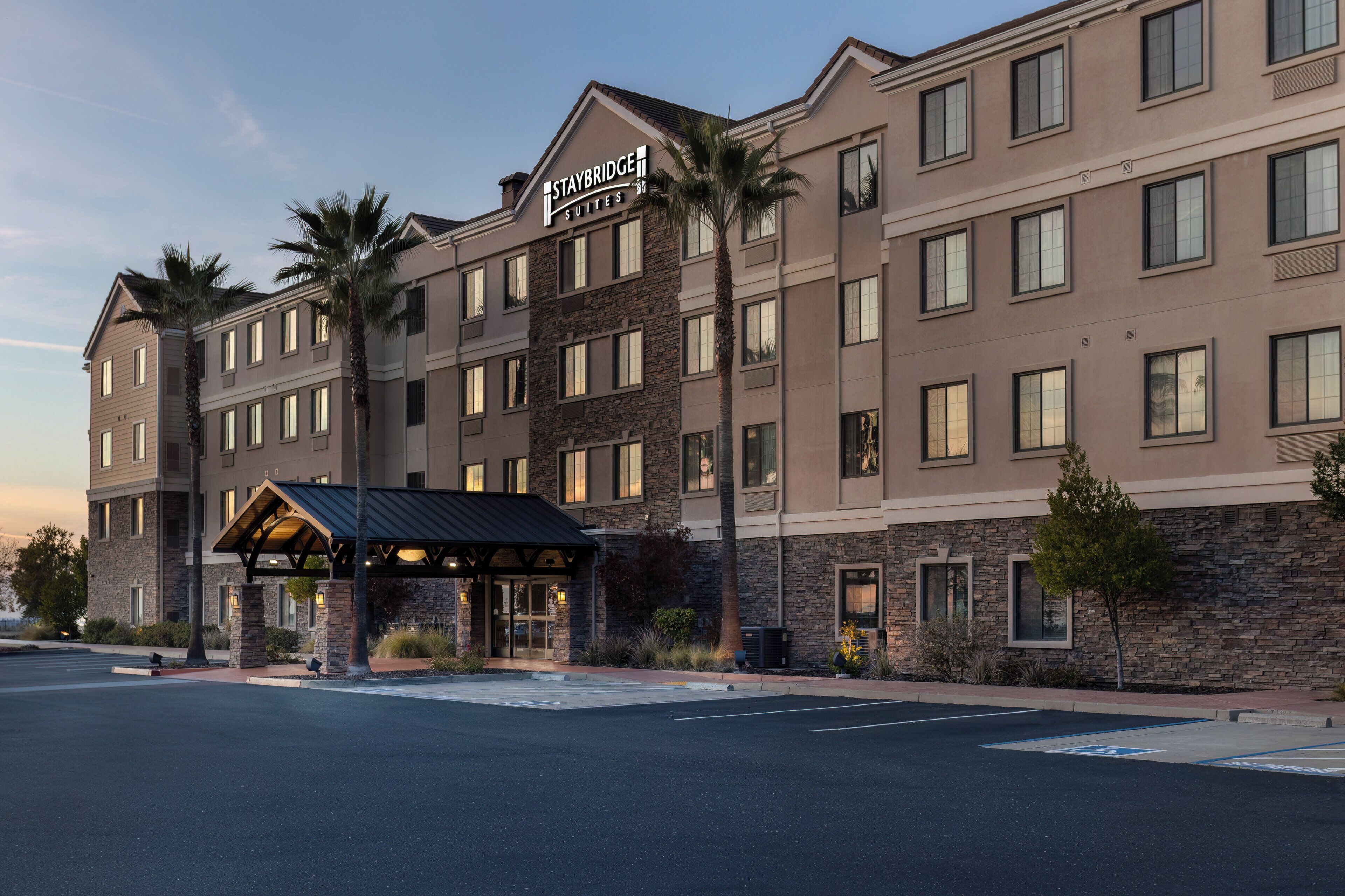 Un hôtel à plusieurs étages, sur lequel on peut lire l’inscription « Staybridge Suites ».