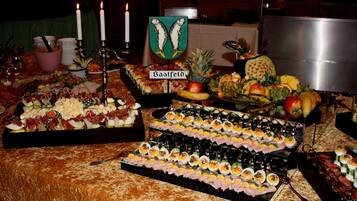 Una mesa de buffet con diversos alimentos, incluyendo un cartel que dice 'Saalfeld'.