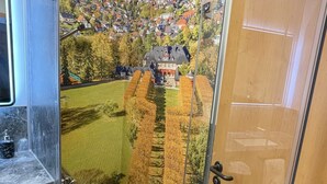 Een badkamer met een glazen douchecabine, een marmeren wastafel en een handdoek op het aanrecht.