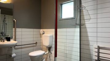 Een moderne badkamer met toilet, wastafel en douche.