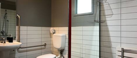 Une salle de bain moderne équipée de toilettes, d’un lavabo et d’une douche.