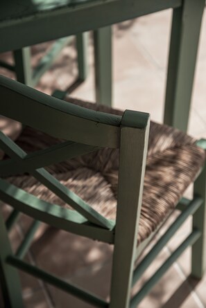 A close-up of a chair with a woven seat and a green metal frame. - Zefyros Village Resort (Zakynthos)