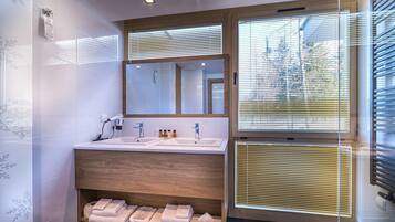 Ein modernes Badezimmer mit Doppelwaschbecken, Holz-Waschtisch und einem großen Spiegel.