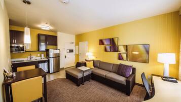 Ein modernes Hotelzimmer mit Küche, Essbereich und Wohnbereich.