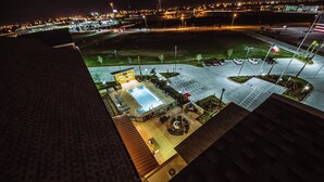 A rooftop pool area with a sunken seating area, a flag, and a parking lot. - Residence Inn Harlingen (Harlingen)