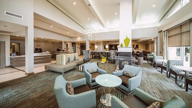 A spacious lobby with seating areas, a reception desk, and a bar. - Residence Inn Harlingen (Harlingen)
