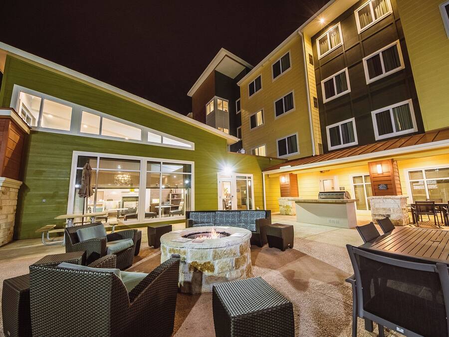 An outdoor patio area with a fire pit, seating, and a bar area.