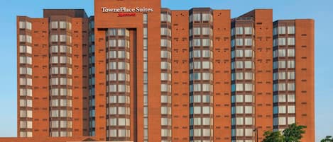 Ein TownePlace Suites Hotel mit Backsteinfassade, mehreren Etagen und blauem Himmel.