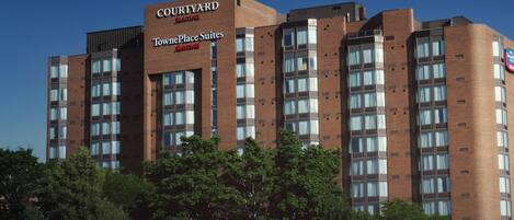 A Courtyard by Marriott hotel with a brick facade, multiple windows, and a sign indicating it is a TownPlace Suites hotel.