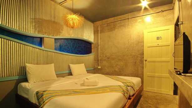A hotel room with a bed, a bathroom, and a television. - Seabox Khaolak Hostel (Takua Pa)