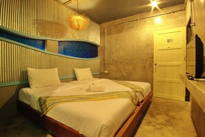 A hotel room with a bed, a bathroom, and a television. - Seabox Khaolak Hostel (Takua Pa)