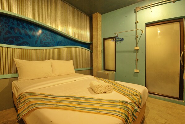 A hotel room with a bed, a bathroom with a towel rack, and a door. - Seabox Khaolak Hostel (Takua Pa)