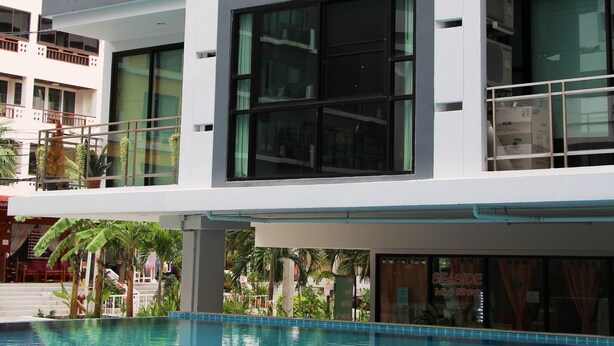 Ein modernes Gebäude mit mehreren Balkonen und einem Pool davor.