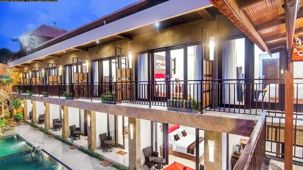 A hotel with a pool, outdoor seating, and multiple balconies. - The Swaha Ubud Hotel (Batubulan)