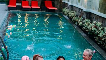 Relax by the pool surrounded by lush greenery and a scenic view.