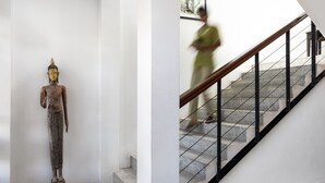 Eine Statue in einer Diele und eine Treppe mit Metallgeländer.
