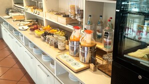 Un espace buffet proposant divers plats, des accompagnements et un réfrigérateur.