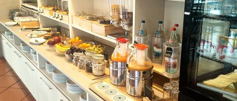 A buffet area with various food items, condiments, and a refrigerator.