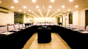 A conference room with a long table, chairs, and a projector. - Jade Hotel & Suites (Makati)