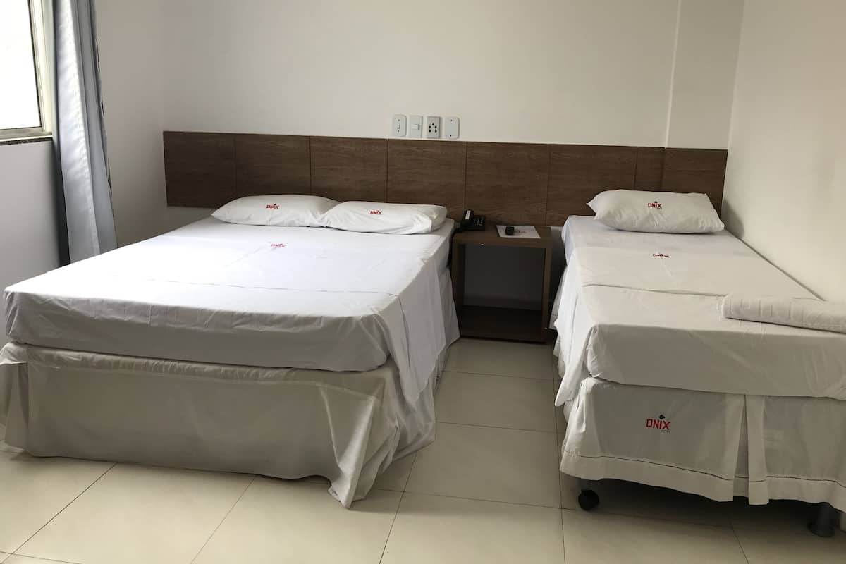 Ein Hotelzimmer mit zwei Einzelbetten, einem Nachttisch mit Telefon und einem Bild an der Wand.