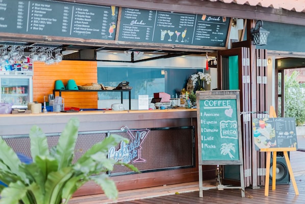 Una cafetería con un tablero que muestra bebidas y precios.