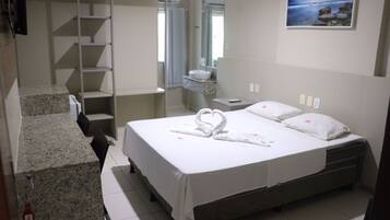 Habitación de hotel con cama, baño, escalera y un cuadro en la pared.