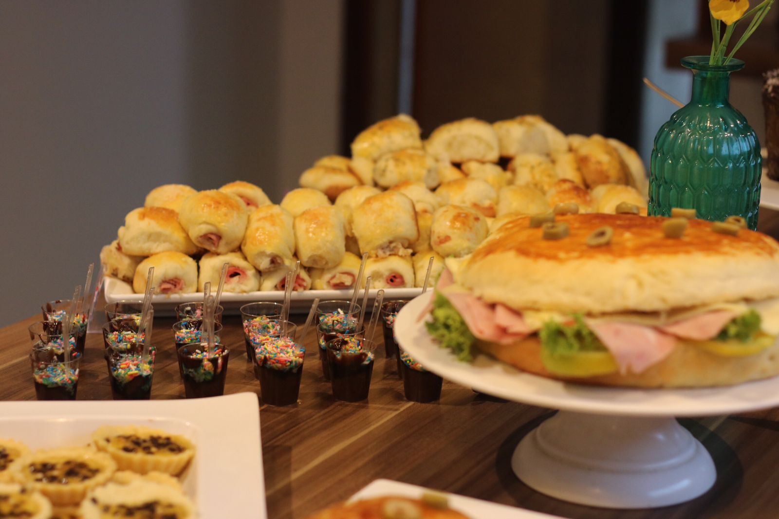 A table with various food items including a sandwich, pastries, and drinks.