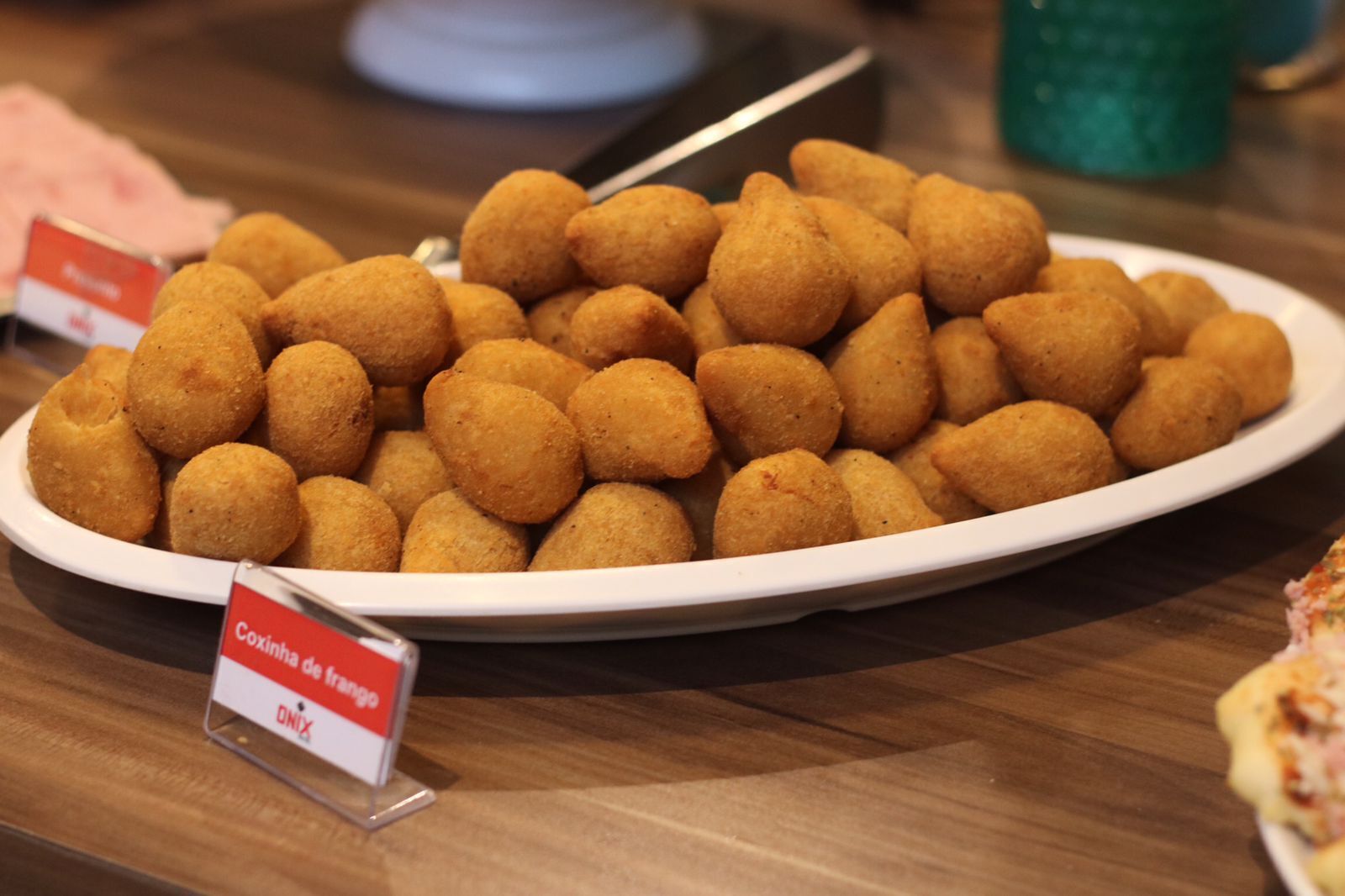 Un plato de Coxinha de mangão sobre una mesa de madera.