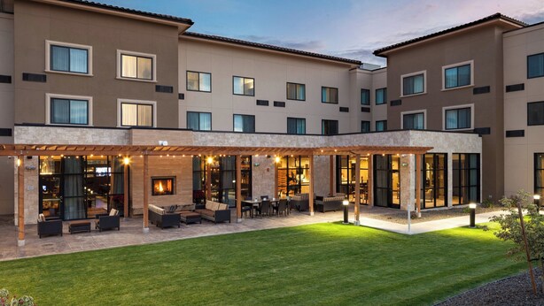 A hotel with a covered outdoor seating area, a well-maintained lawn, and a modern building facade. - Courtyard by Marriott Walla Walla (Walla Walla)