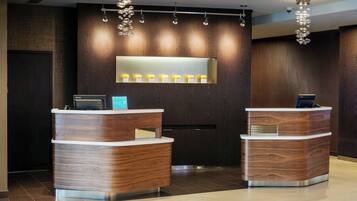 A reception desk with a modern design, featuring two counters and a large illuminated sign above.