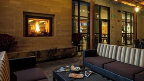An outdoor seating area with a fire feature, a sofa, and a table with food and drinks. - Courtyard by Marriott Walla Walla (Walla Walla)