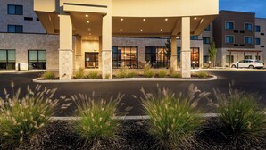 A hotel with a covered entrance, stone facade, and a parking area with a landscaped garden. - Courtyard by Marriott Walla Walla (Walla Walla)