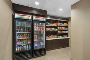 A vending area with two refrigerated beverage dispensers and shelves stocked with snacks and beverages. - Holiday Inn Express & Suites Houston NW - Tomball Area by IHG (Tomball)