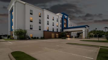 A large, multi-story hotel with a prominent entrance and a parking lot.