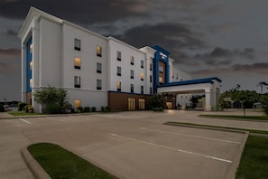 A large, multi-story hotel with a prominent entrance and a parking lot. - Hampton Inn Marion (Marion)