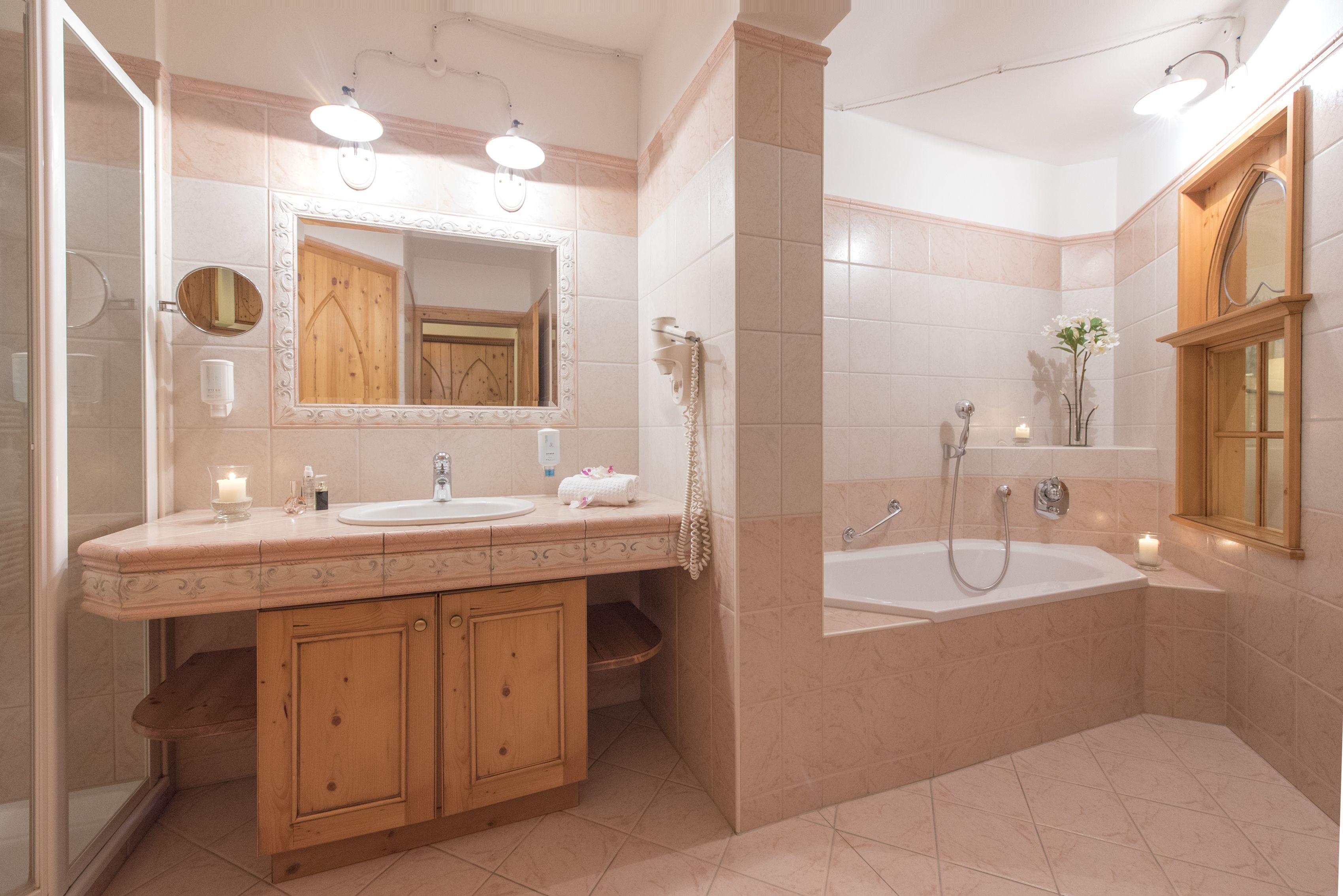 Ein Badezimmer mit einem Doppelwaschtisch, einem großen Spiegel, einer Badewanne und einer Dusche.