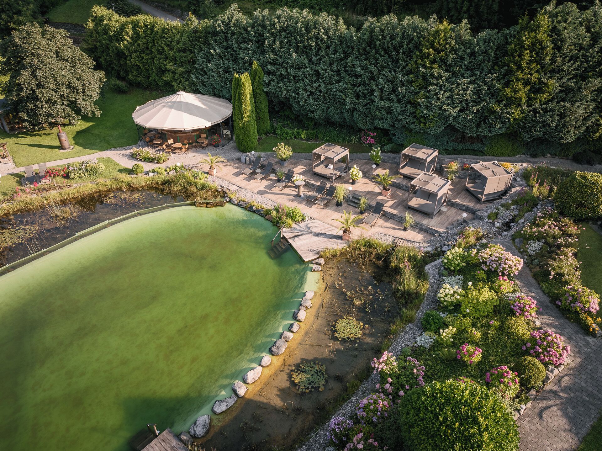 Ein Golfplatz mit Putting-Green, Liegestühlen und einer überdachten Sitzgelegenheit.
