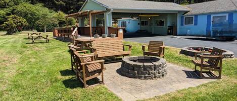 A lodge with outdoor seating, a fire pit, and a covered picnic area.