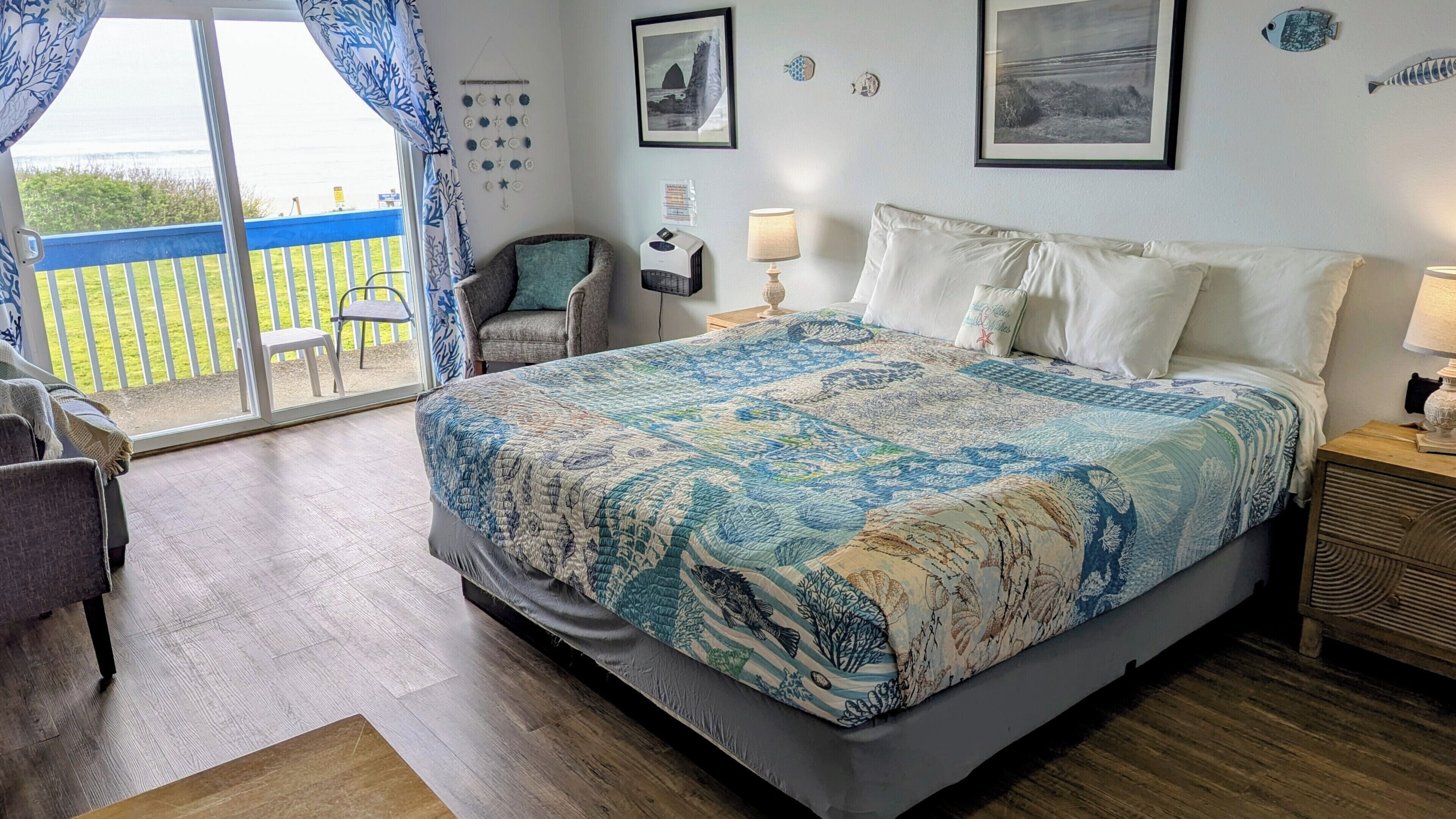 Une chambre avec un grand lit, une chaise, un bureau et une vue sur l’extérieur.
