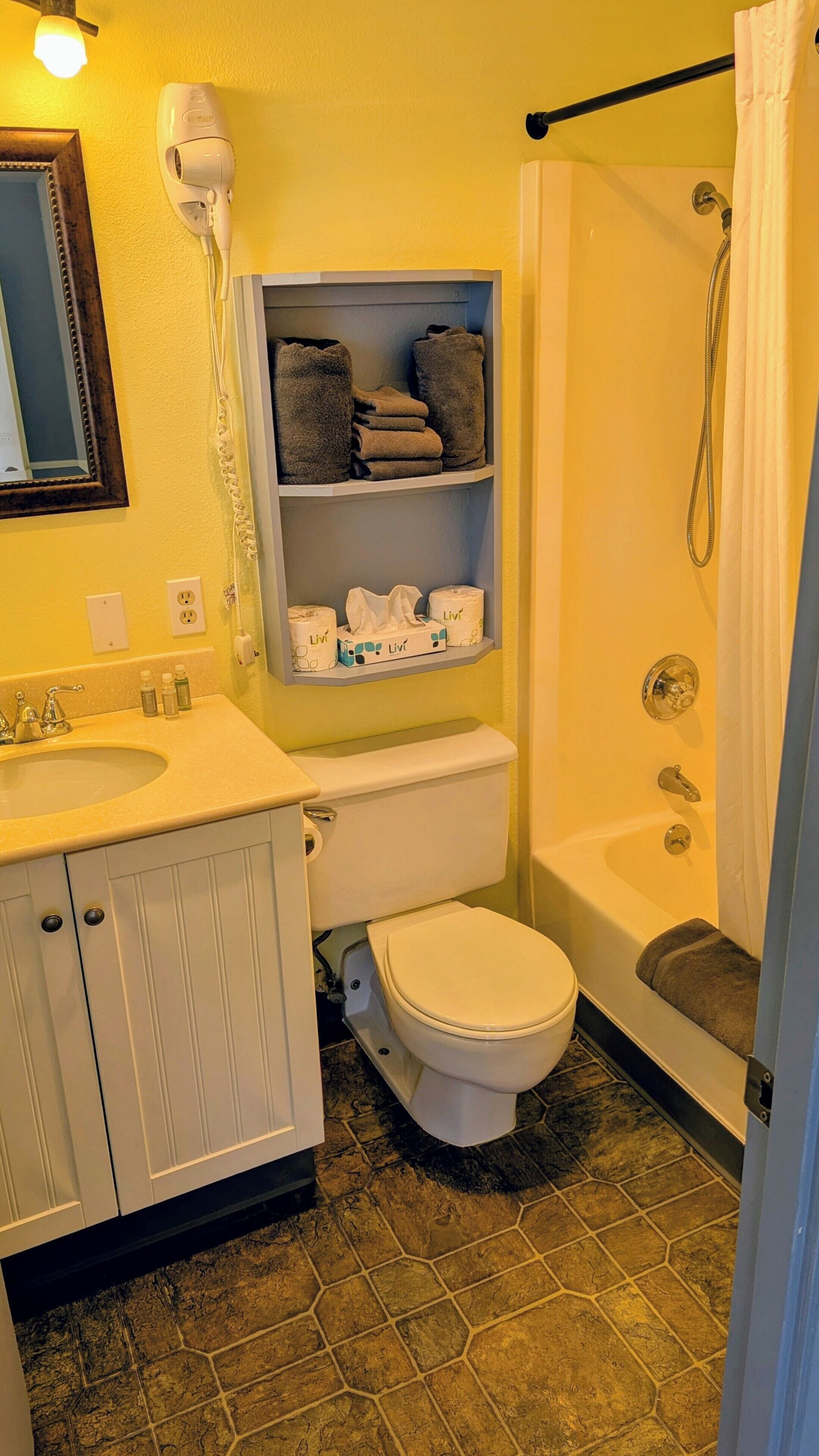 A bathroom with a toilet, sink, and shower.