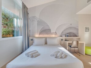 A hotel room with a bed, a desk, and a chair. There are towels on the bed. - B&B HOTEL Bergamo City (Bergamo)