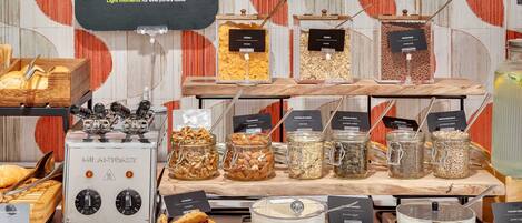 A breakfast buffet with various food options including cereals, nuts, and yogurt.