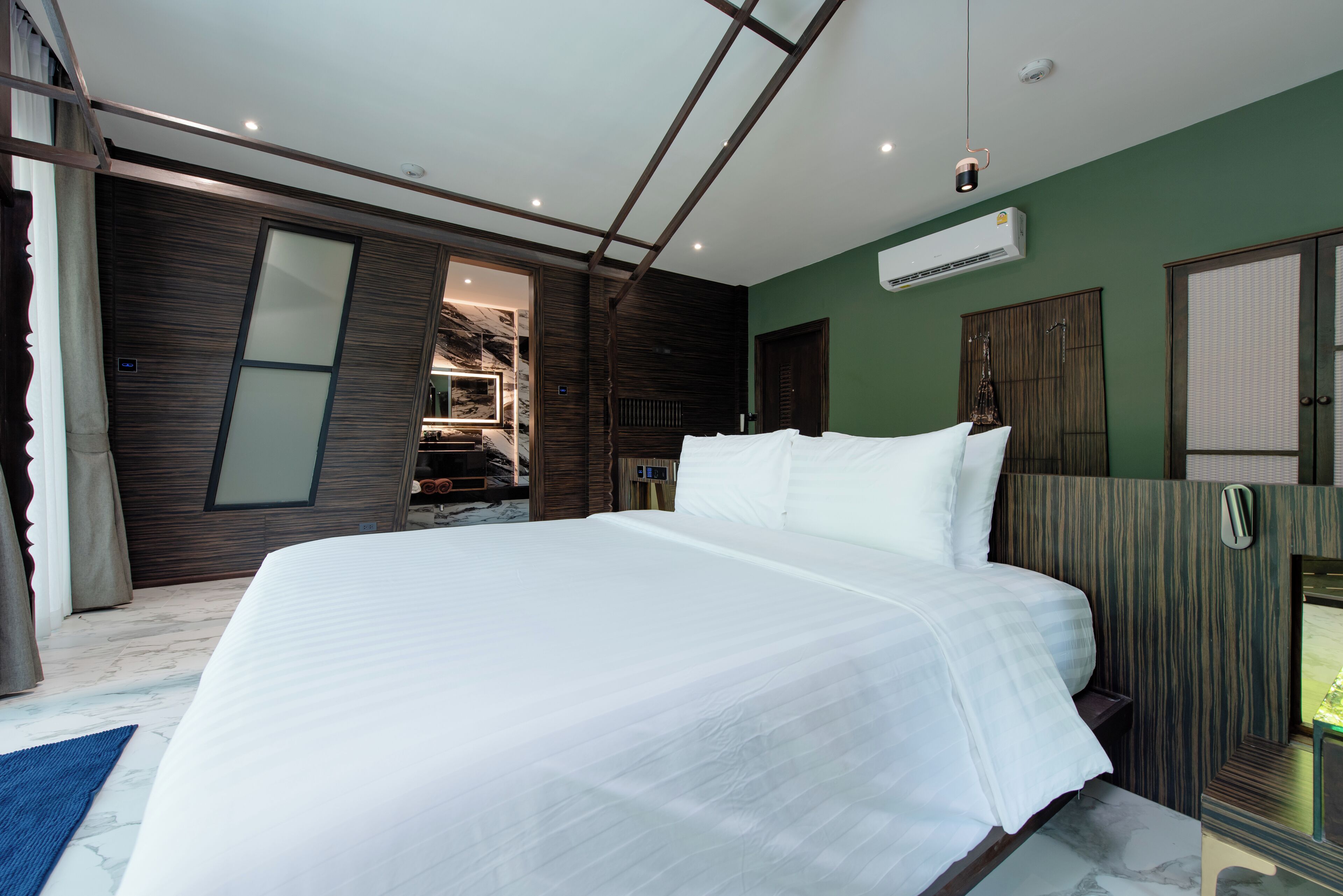 A modern bedroom with a large bed, wooden paneling, and a built-in wardrobe.