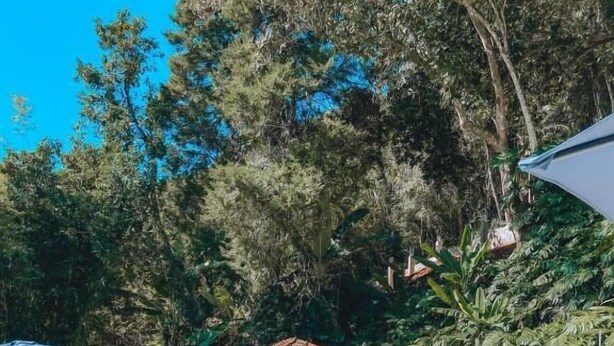 A swimming pool with lounge chairs, a gazebo, and lush greenery in the background. - Pousada Princesa Isabel - Visconde (Petrópolis)