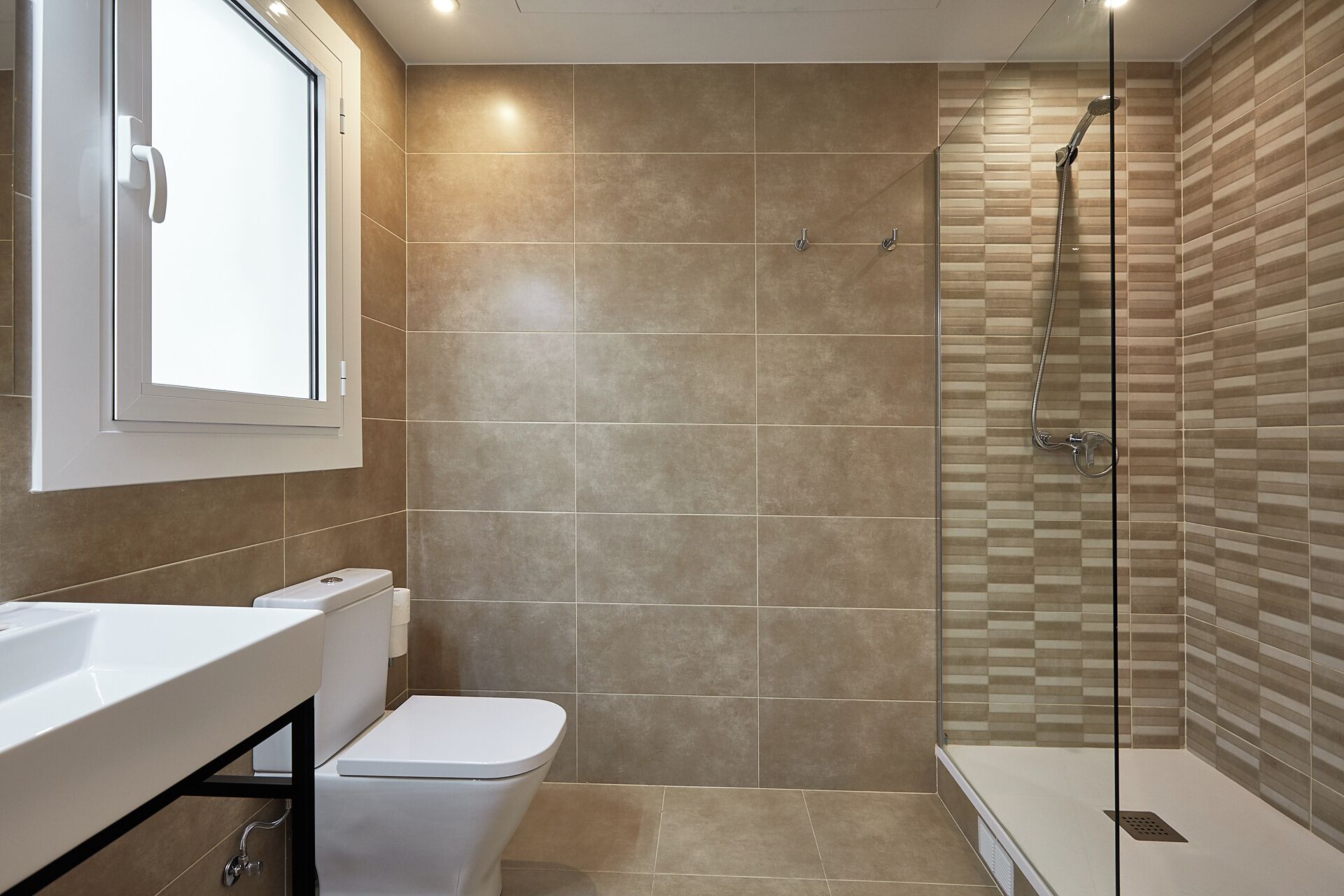 A bathroom with a shower, toilet, and sink.