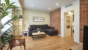 Una sala moderna con un sofá modular, una mesa de centro y una planta en maceta.