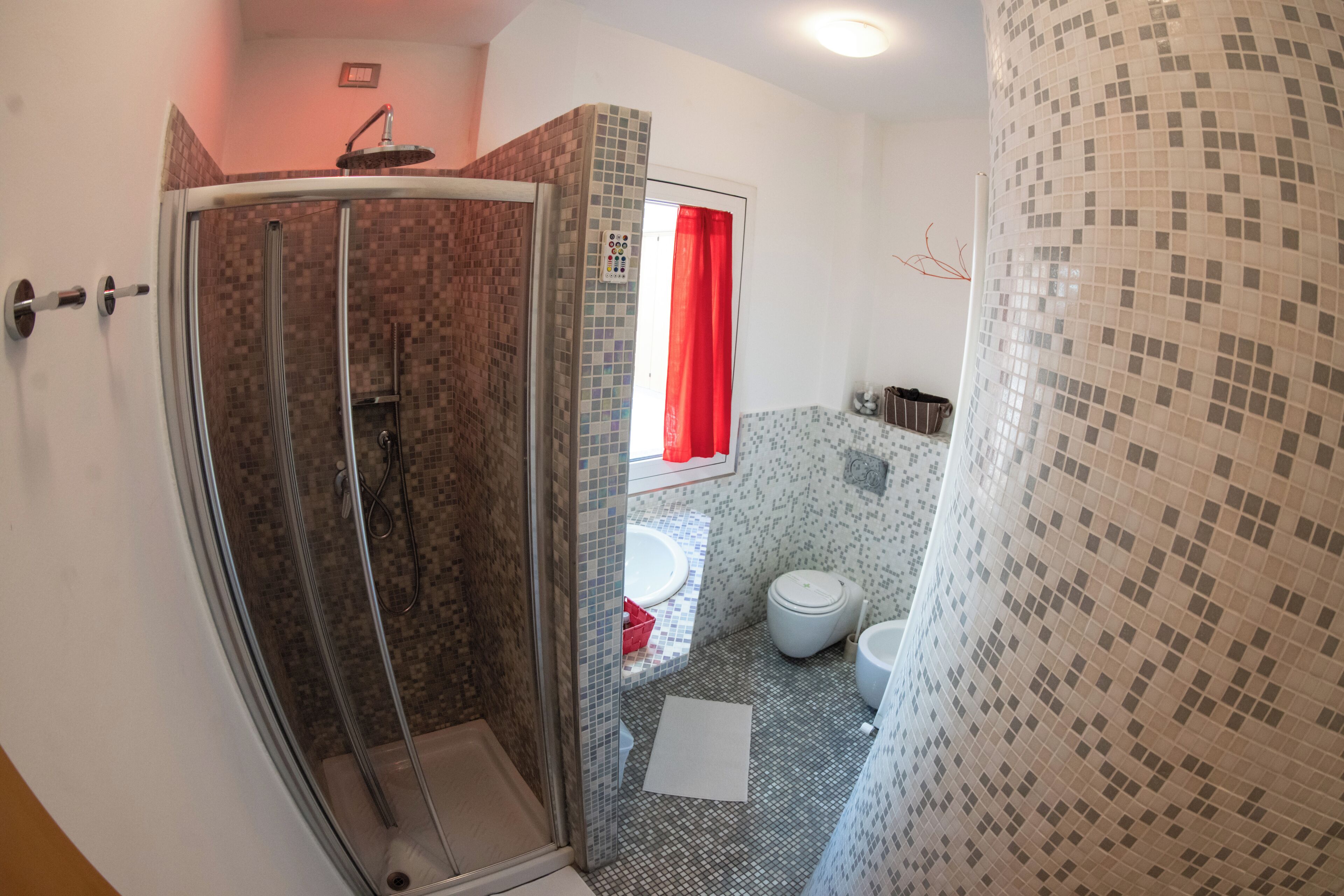 A bathroom with a shower, toilet, and sink.