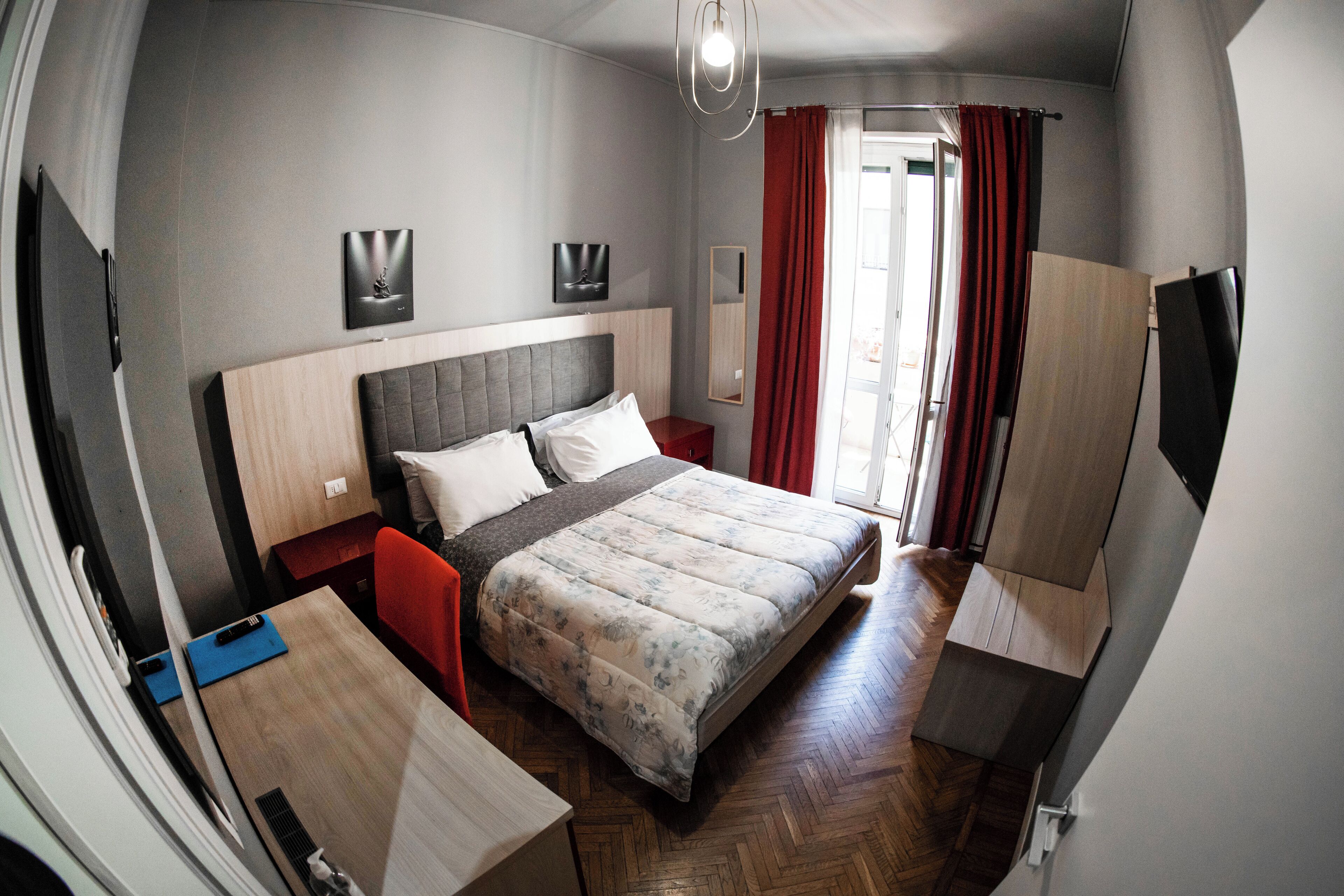 Una habitación de hotel moderna con una cama grande, un escritorio, una silla y un televisor.