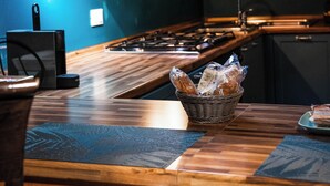 A kitchen with wooden countertops, a stove, and a basket of bread. - La Residenza Isabella (Milan)