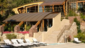 A modern resort with a pool area, lounge chairs, and a staircase leading to the building. - Termas Jahuel Hotel & Spa (Santa Maria)